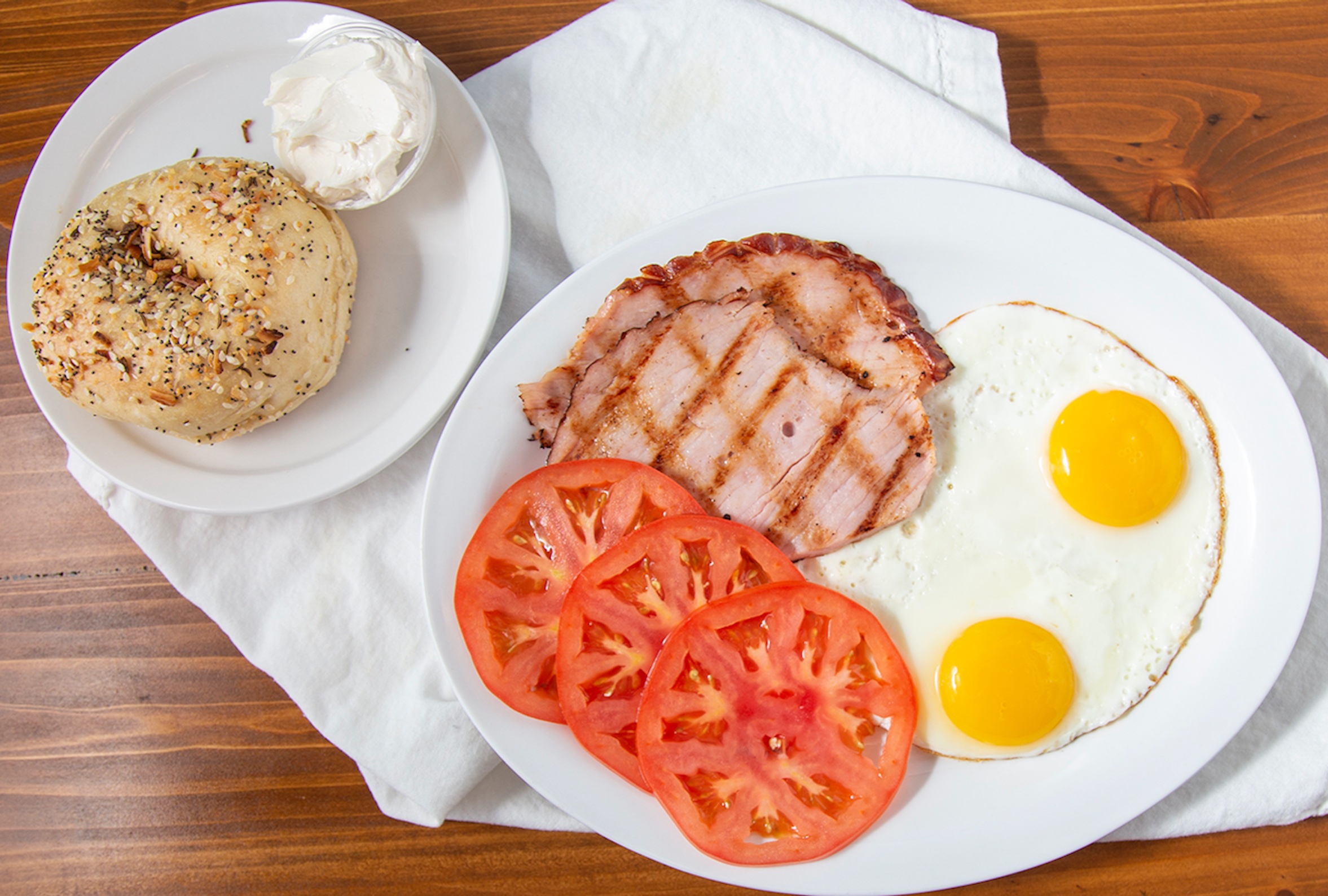 Breakfast plate with bagel, ham and eggs