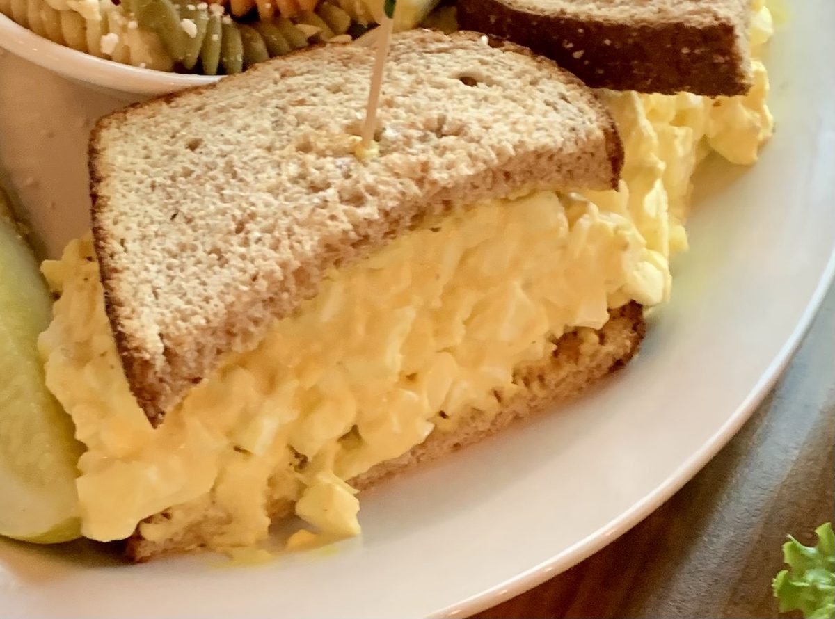 Egg salad sandwich on wheat with pickle