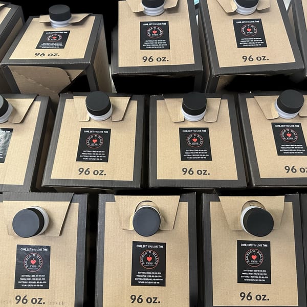 Rows of 96 oz. New York Bagels 'N Bialys branded juice cartons with black caps.