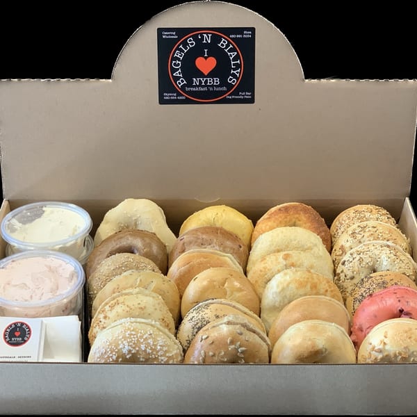 A catering box from New York Bagels 'N Bialys filled with assorted bagels and cream cheese.