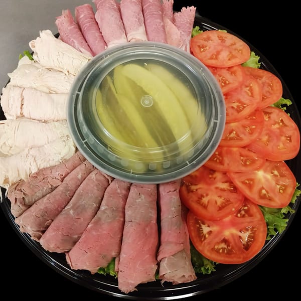 Deli platter with sliced turkey, roast beef, corned beef, tomatoes, lettuce, and pickles from New York Bagels `N Bialys.